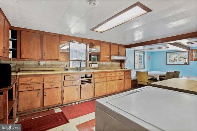 a kitchen with a sink appliances cabinets and furniture
