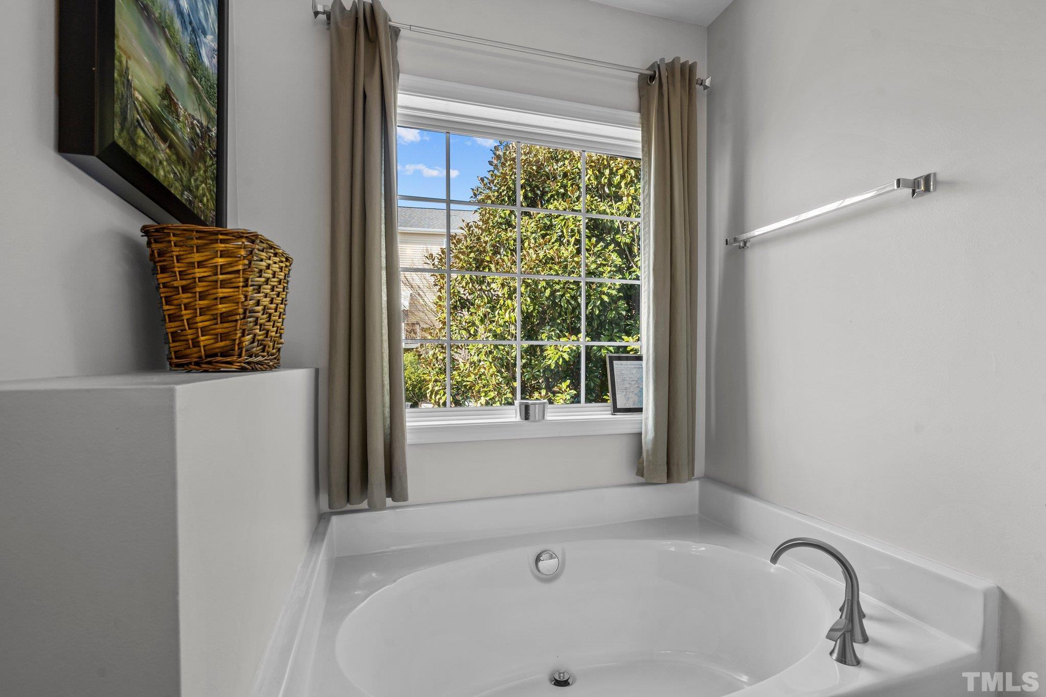 2359 Spruce Shadows Lane Raleigh, NC 27614 - Photo 18 of 34 a bathroom with a bathtub and window
