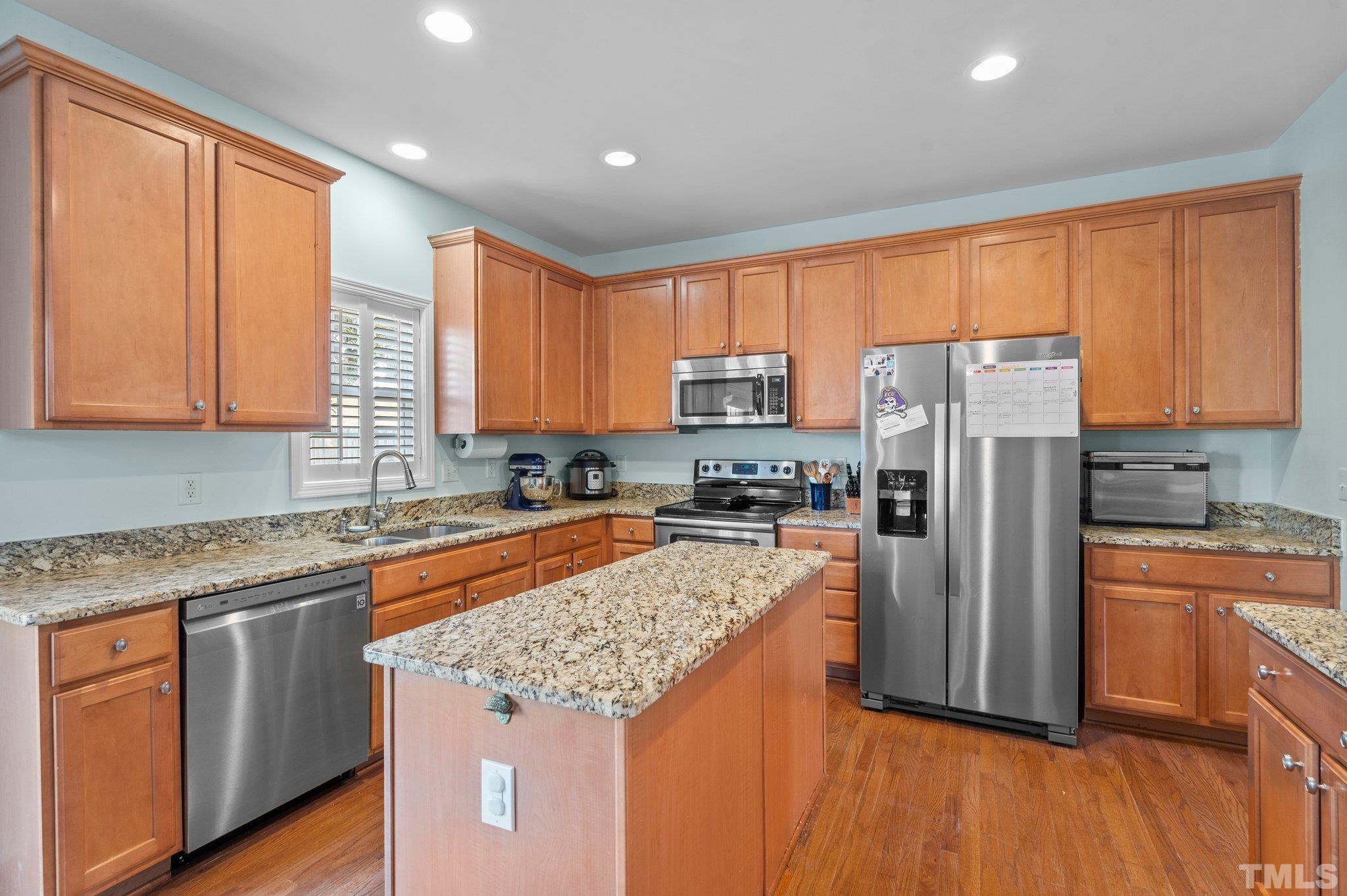 2359 Spruce Shadows Lane Raleigh, NC 27614 - Photo 3 of 34 a kitchen with stainless steel appliances granite countertop a refrigerator a sink dishwasher a stove and white countertops with wooden floor