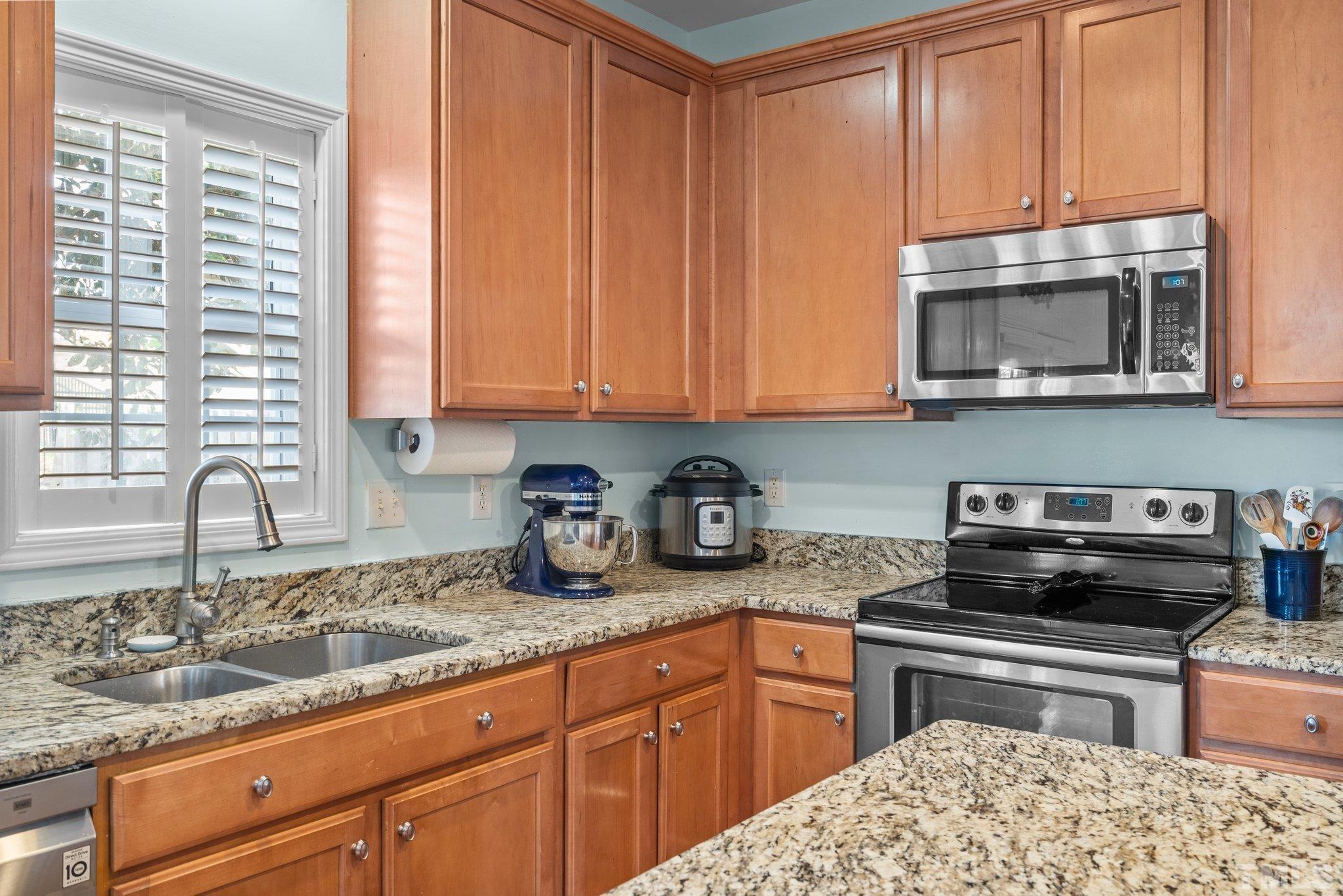 2359 Spruce Shadows Lane Raleigh, NC 27614 - Photo 5 of 34 a kitchen with granite countertop a sink and a stove