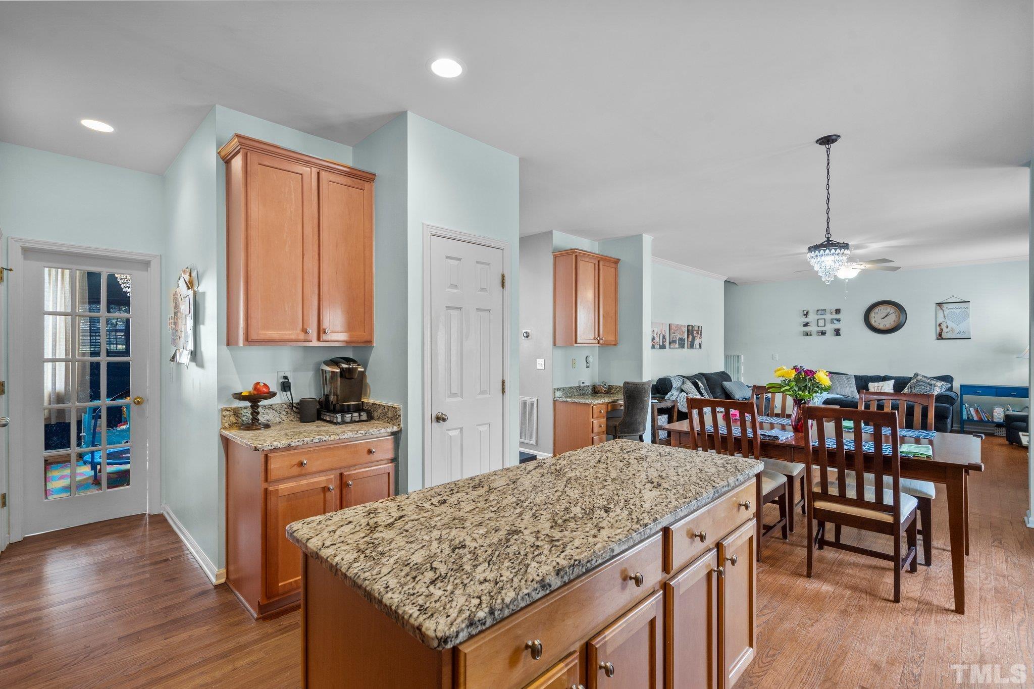 2359 Spruce Shadows Lane Raleigh, NC 27614 - Photo 7 of 34 a kitchen with stainless steel appliances granite countertop a stove top oven a dining table and chairs with wooden floor