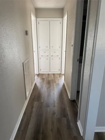 a view of a hallway with wooden floor