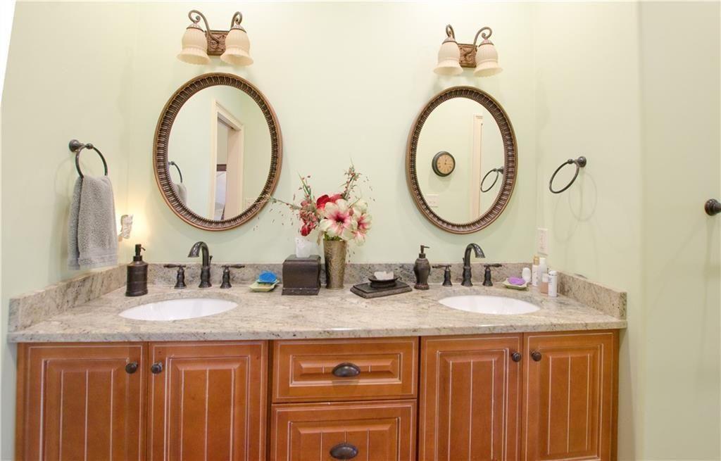 1331 Barrows Grove Road Madison, GA 30650 - Photo 15 of 47 a bathroom with a granite countertop double vanity and a mirror