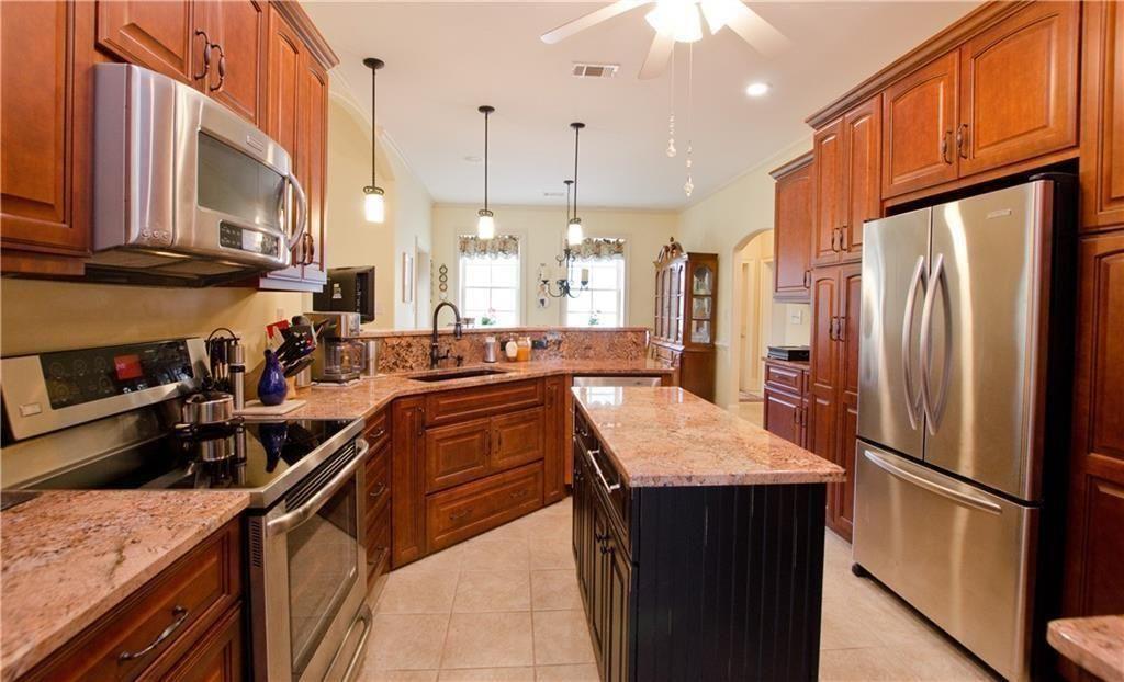 1331 Barrows Grove Road Madison, GA 30650 - Photo 10 of 47 a kitchen with stainless steel appliances granite countertop a refrigerator a stove and a sink