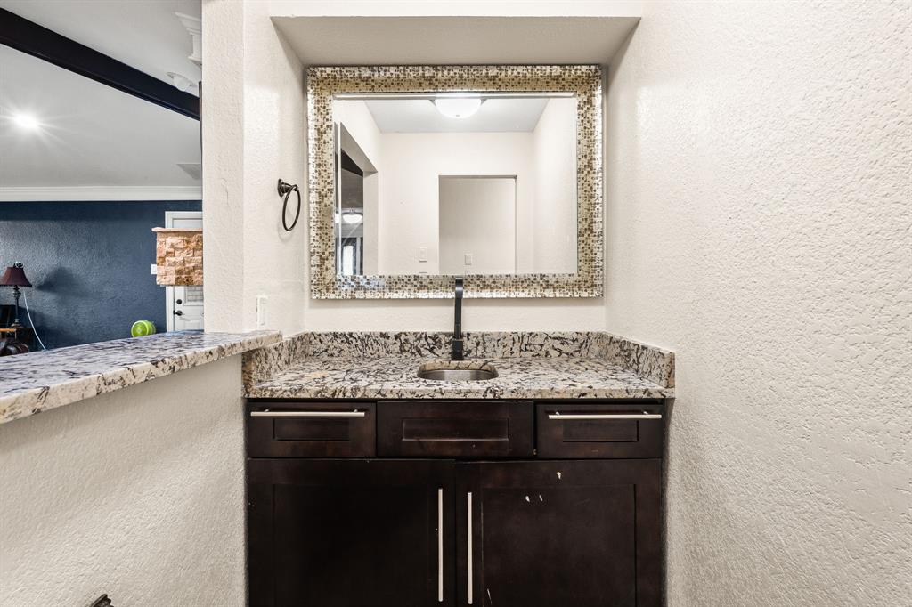 9552 Timberleaf Drive Dallas, TX 75243 - Photo 11 of 38 a bathroom with a granite countertop sink a mirror and vanity
