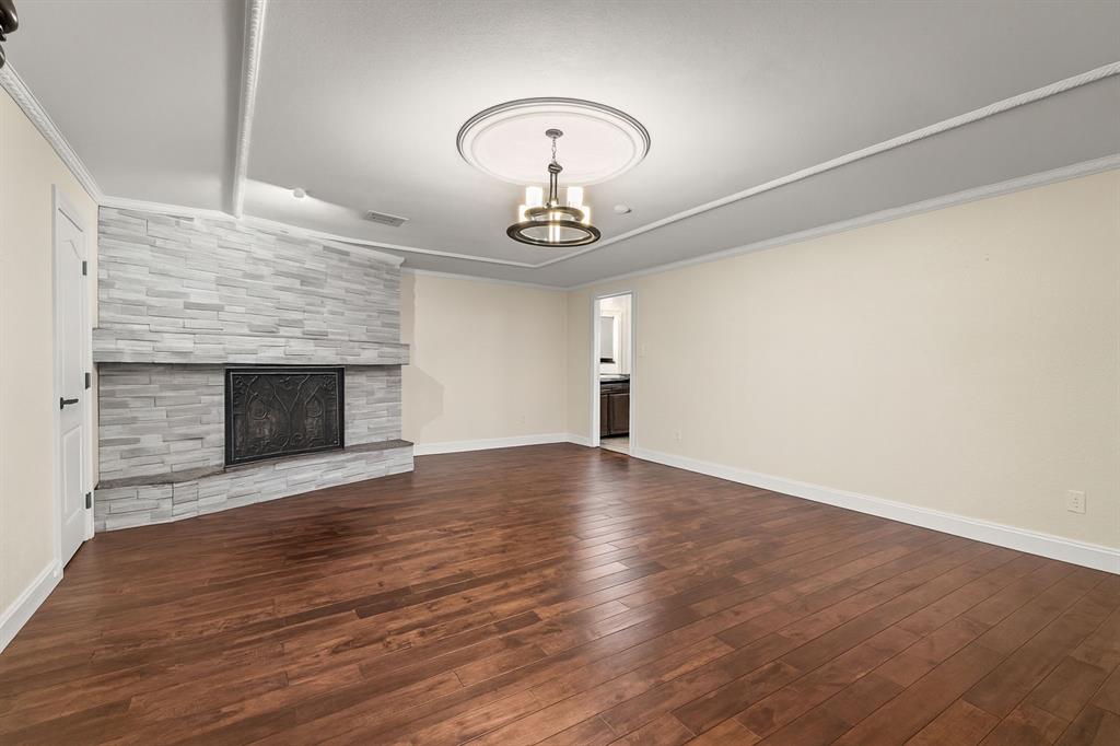 9552 Timberleaf Drive Dallas, TX 75243 - Photo 12 of 38 wooden floor in an empty room with a fireplace