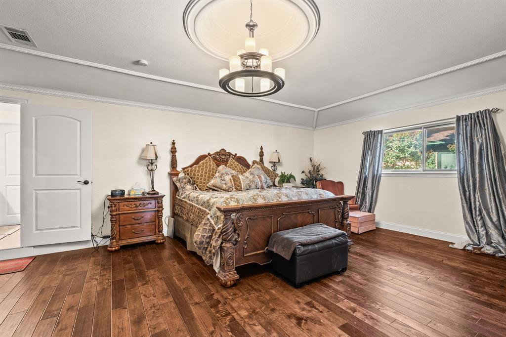 9552 Timberleaf Drive Dallas, TX 75243 - Photo 14 of 38 a bedroom with a bed and wooden floor