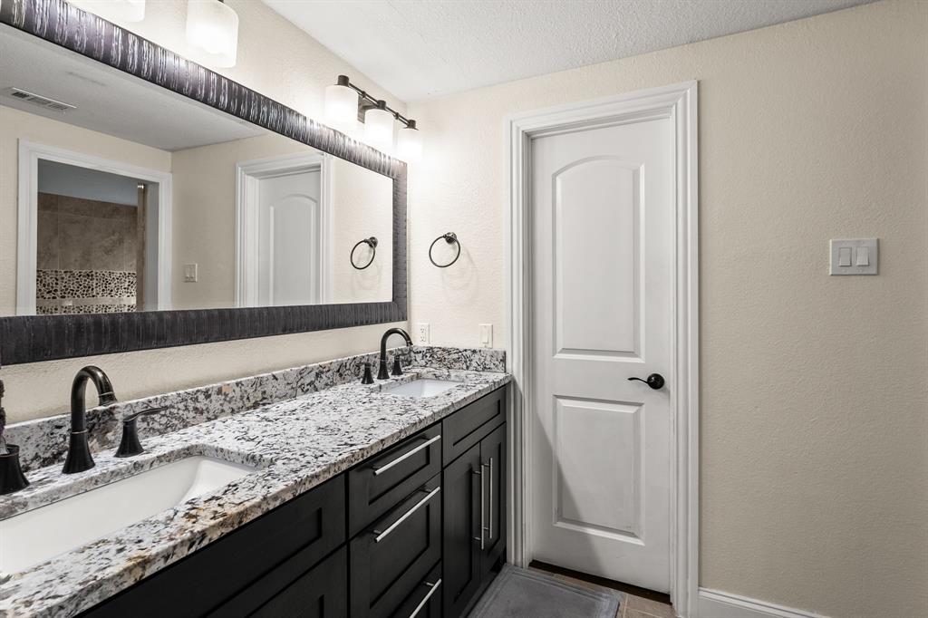 9552 Timberleaf Drive Dallas, TX 75243 - Photo 18 of 38 a bathroom with a granite countertop sink and a mirror