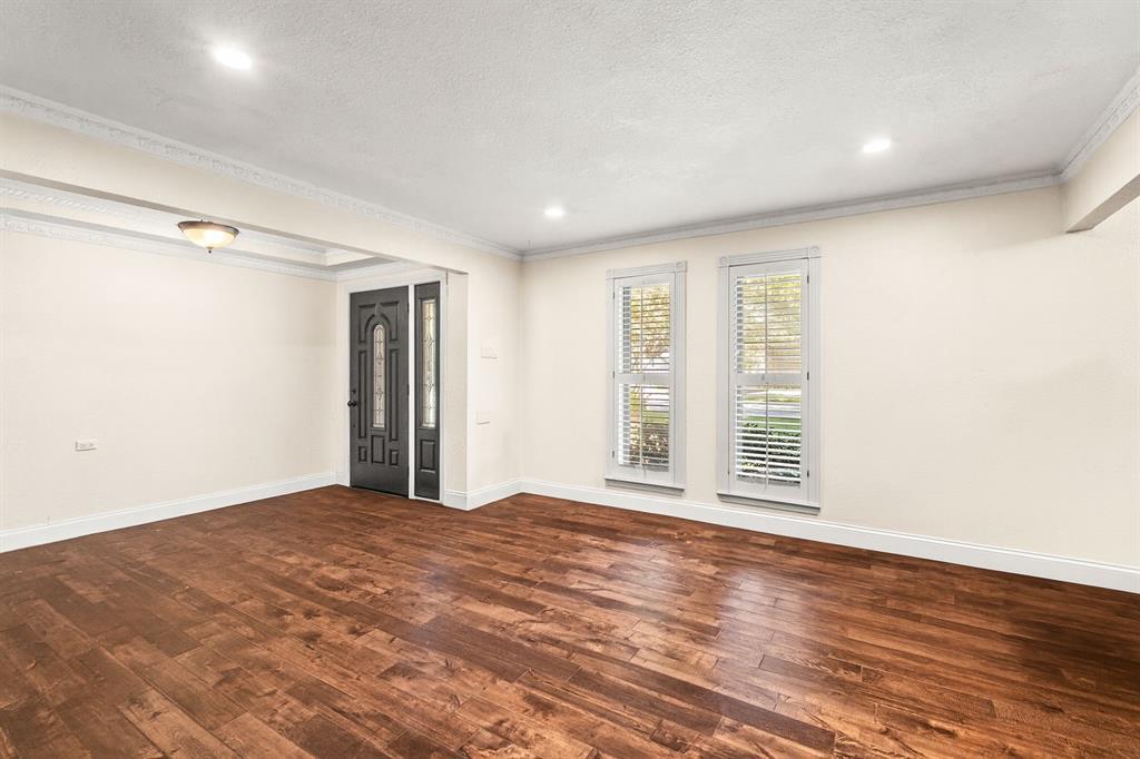 9552 Timberleaf Drive Dallas, TX 75243 - Photo 2 of 38 a view of an empty room with wooden floor and a window