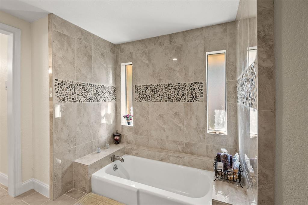 9552 Timberleaf Drive Dallas, TX 75243 - Photo 21 of 38 a white bath tub sitting next to a bathroom