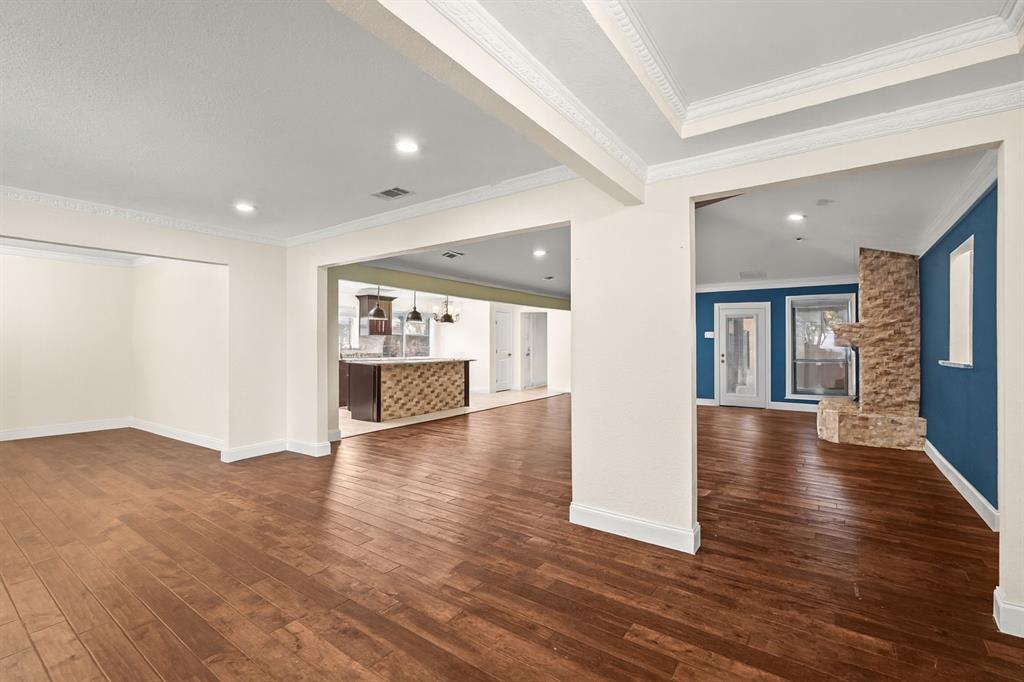 9552 Timberleaf Drive Dallas, TX 75243 - Photo 8 of 38 a view of an empty room with wooden floor and a kitchen