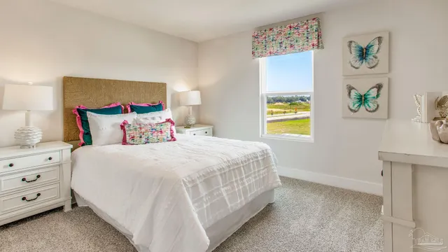 a bedroom with a bed and a lamp on dresser