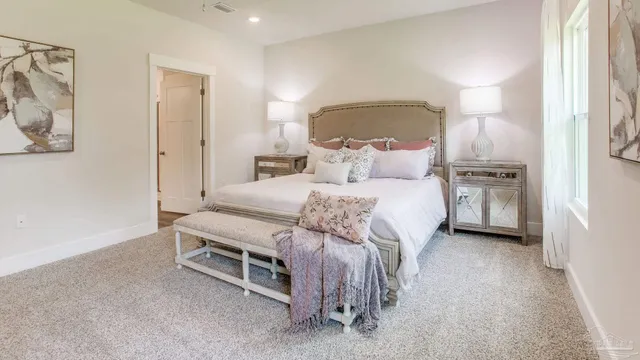 a bedroom with a bed a couch and a view of bathroom