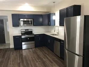 a kitchen with stainless steel appliances and wooden cabinets