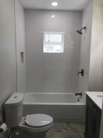 a bathroom with a toilet bathtub and shower