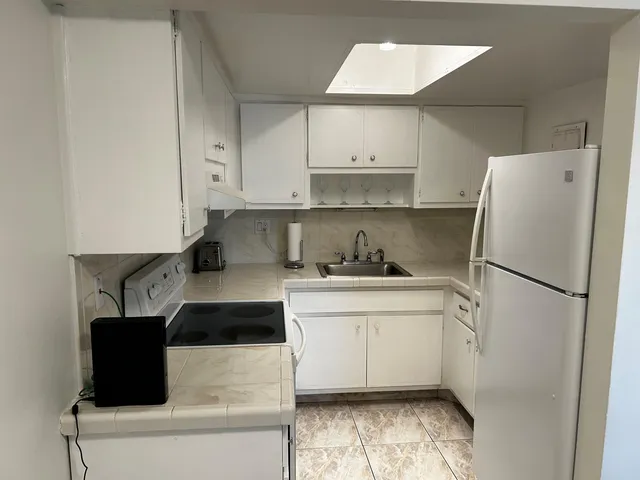 a kitchen with a refrigerator sink stove and cabinets