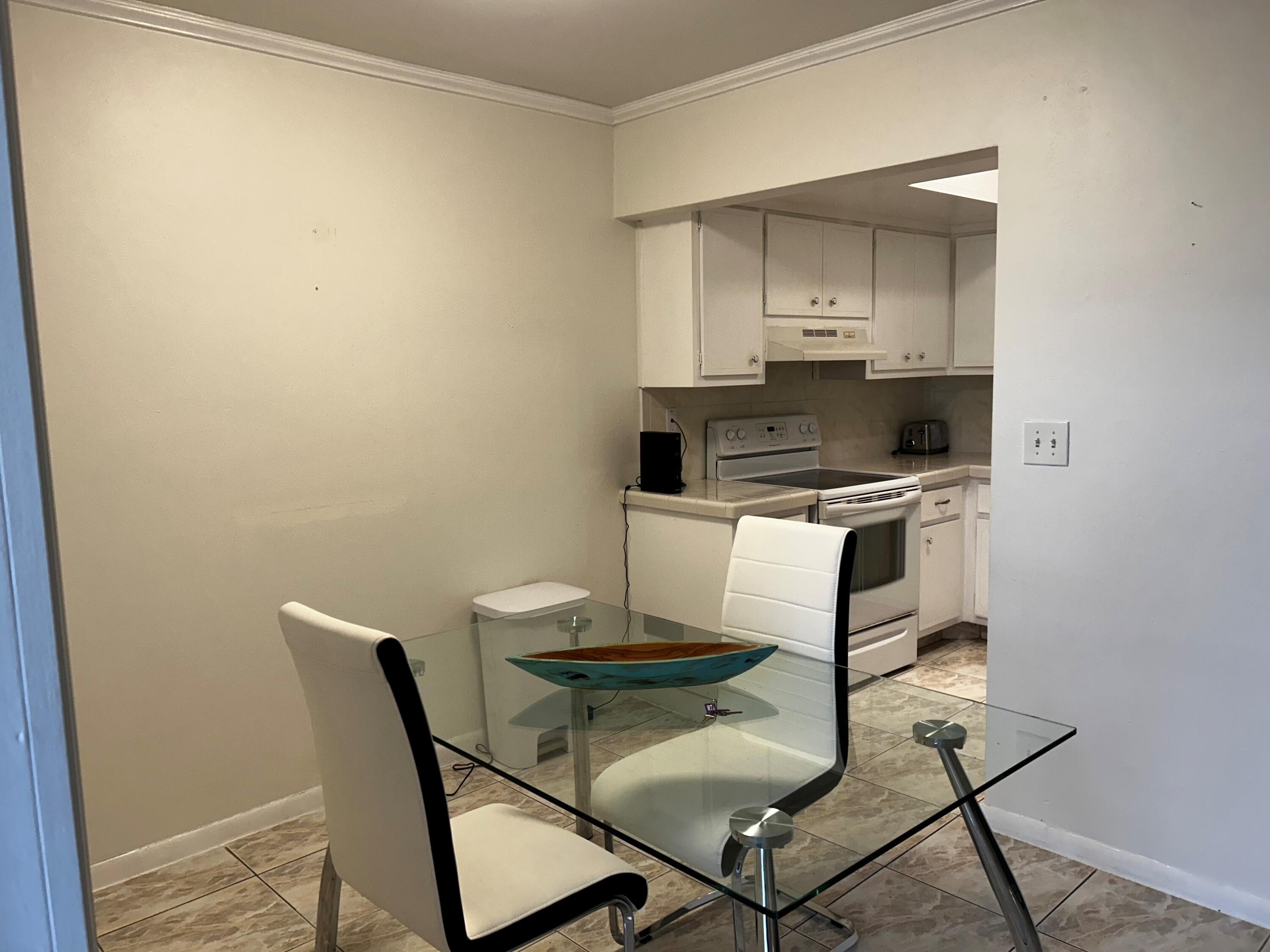 3220 Northeast 10th Street, Unit 15 Pompano Beach, FL 33062 - Photo 5 of 6 a kitchen with a table and chairs