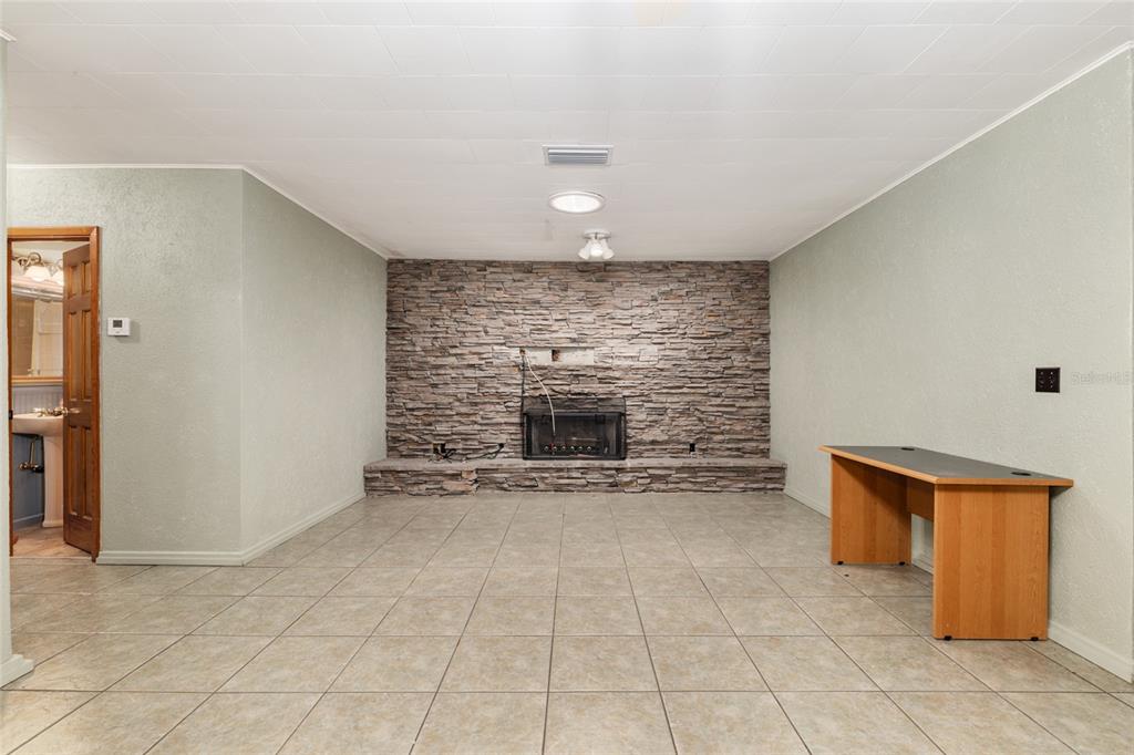 4367 Highway 301 Bushnell, FL 33513 - Photo 12 of 44 an empty room with a fireplace and painted walls