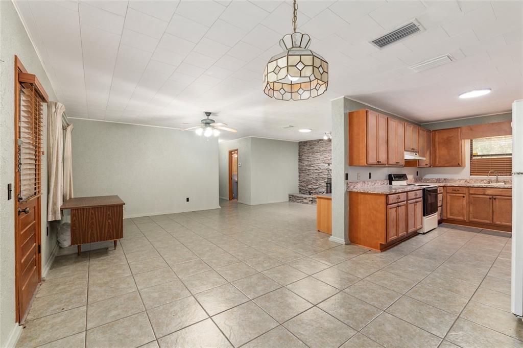 4367 Highway 301 Bushnell, FL 33513 - Photo 9 of 44 a large kitchen with stainless steel appliances granite countertop a stove a sink dishwasher and a refrigerator