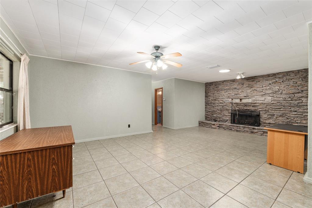 4367 Highway 301 Bushnell, FL 33513 - Photo 10 of 44 an empty room with fireplace and fan