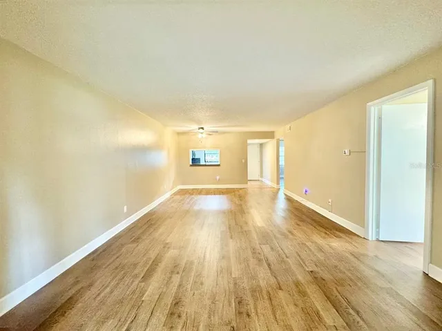 a view of empty room with wooden floor
