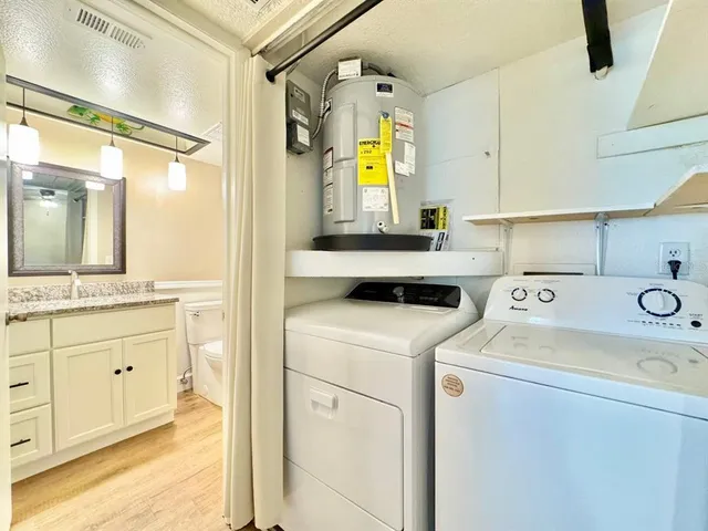 a view of bathroom with a sink and a washer dryer