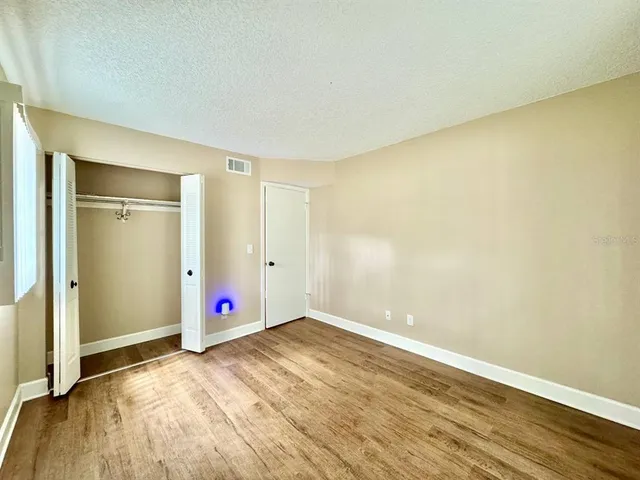 an empty room with wooden floor and entryway