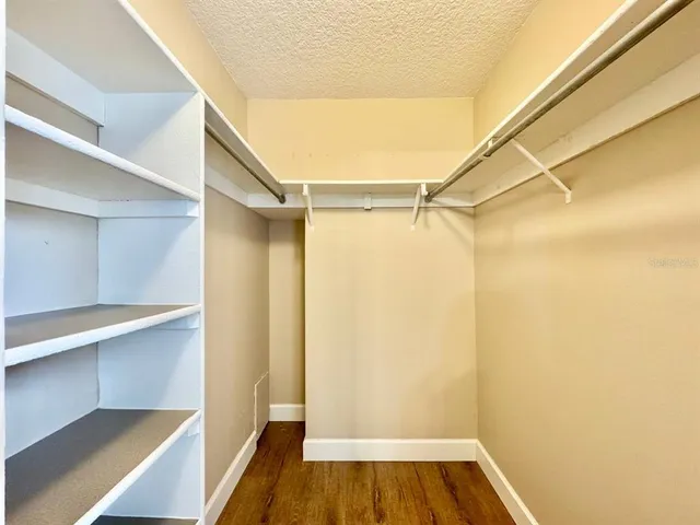a view of walk in closet with wooden floor