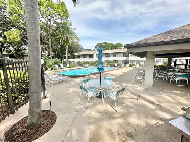a view of a patio with a table and chairs and potted plants