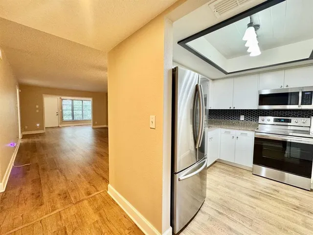 a kitchen with stainless steel appliances granite countertop a refrigerator and a stove top oven