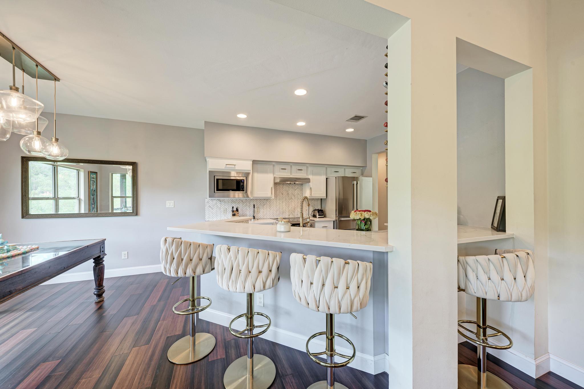 2605 Indian Creek Road Austin, TX 78734 - Photo 6 of 33 Kitchen featuring stainless steel appliances, light cabinetry, and a textured backsplash
