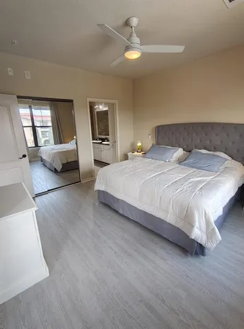 a bedroom with a large bed chandelier and a window