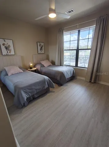 a bedroom with two beds and a large window