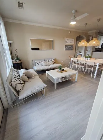 a living room with furniture and a wooden floor