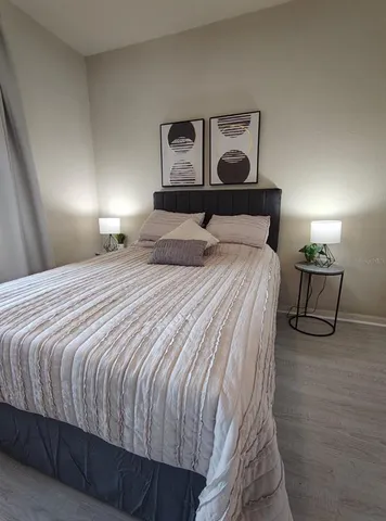 a bedroom with a bed and painting on the wall