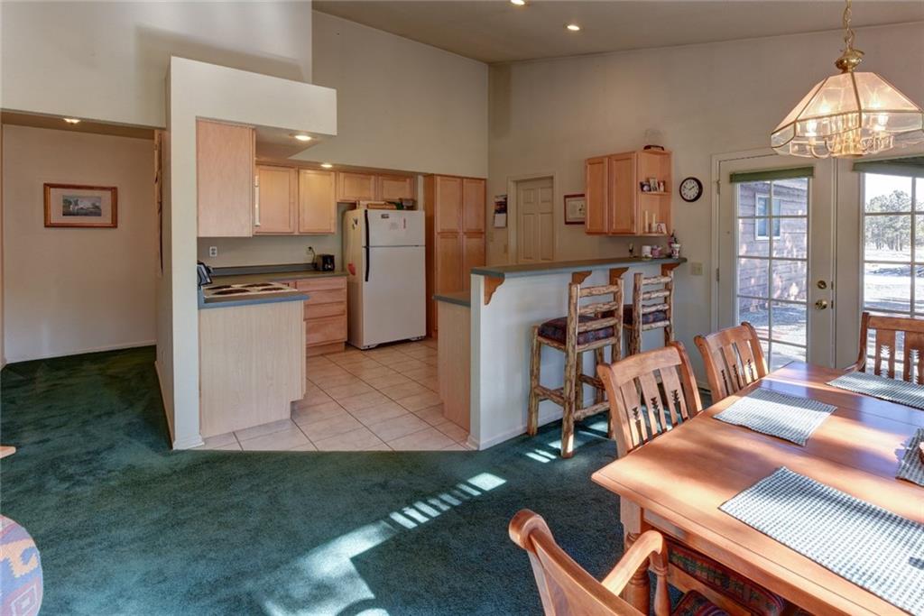 2315 Singletree Road Hartsel, CO 80449 - Photo 9 of 30 a kitchen with stainless steel appliances kitchen island granite countertop a refrigerator a stove a sink dishwasher and white countertops with wooden floor