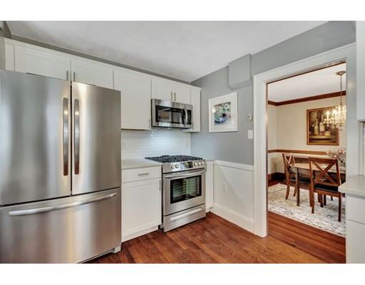 21 Homewood Road Boston, MA 02132 - Photo 14 of 25 a kitchen with stainless steel appliances a refrigerator a stove a dining table and chairs