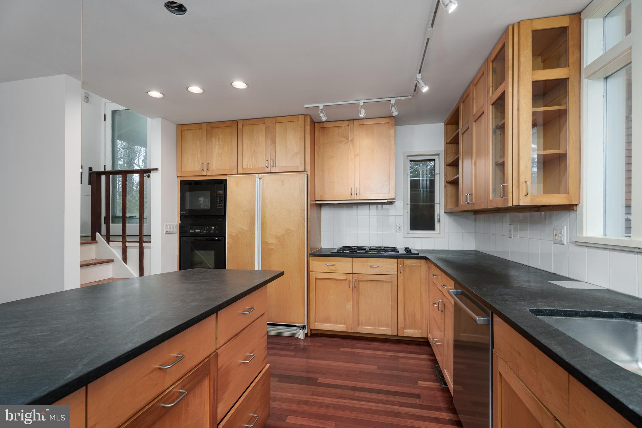 505 Prospect Avenue Princeton, NJ 08540 - Photo 6 of 28 a kitchen with stainless steel appliances granite countertop a refrigerator a stove and a sink with wooden floor