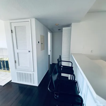 a view of a hallway with wooden floor and windows