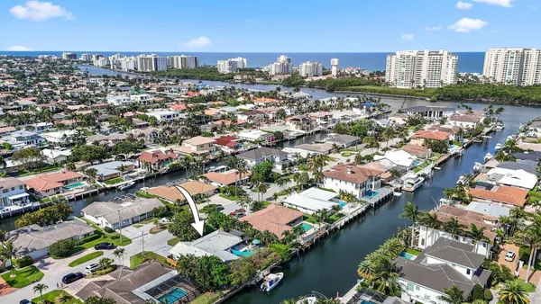 an aerial view of a city with lots of residential buildings ocean and mountain view in back