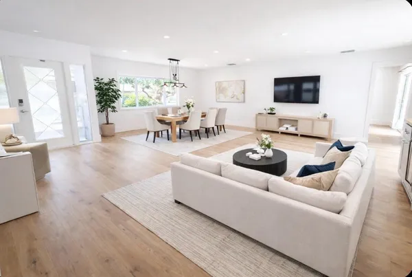 a living room with furniture a flat screen tv and kitchen view