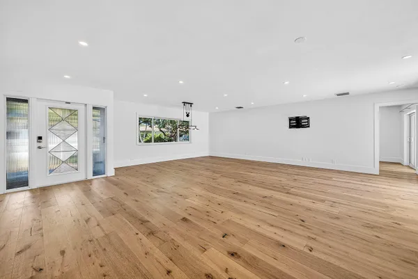 a view of empty room with wooden floor and window
