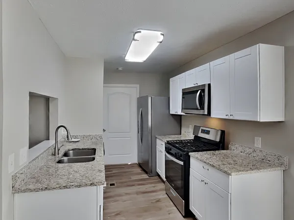 a kitchen with stainless steel appliances granite countertop a sink stove and refrigerator