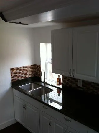 a kitchen with granite countertop a sink and cabinets