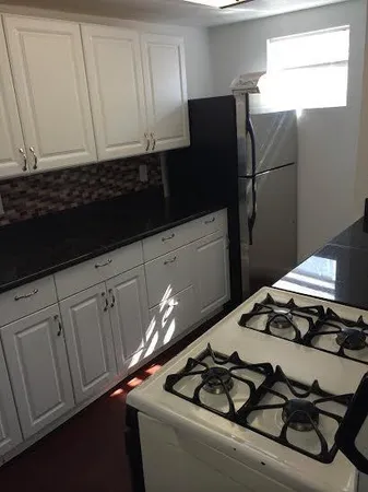 a kitchen with a refrigerator and a stove
