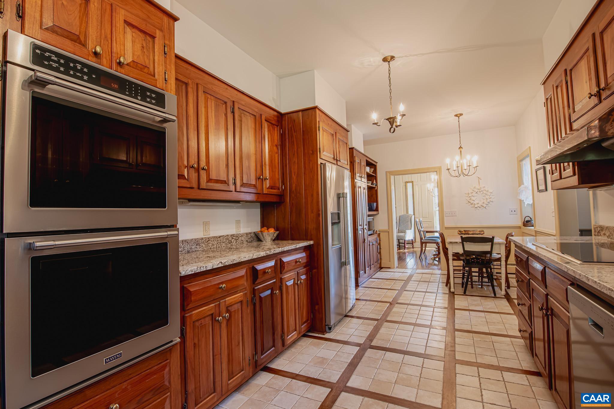 263 Baynes Road Waynesboro, VA 22980 - Photo 17 of 74 a kitchen with stainless steel appliances kitchen island granite countertop a stove top oven a sink dishwasher a dining table and chairs with wooden floor