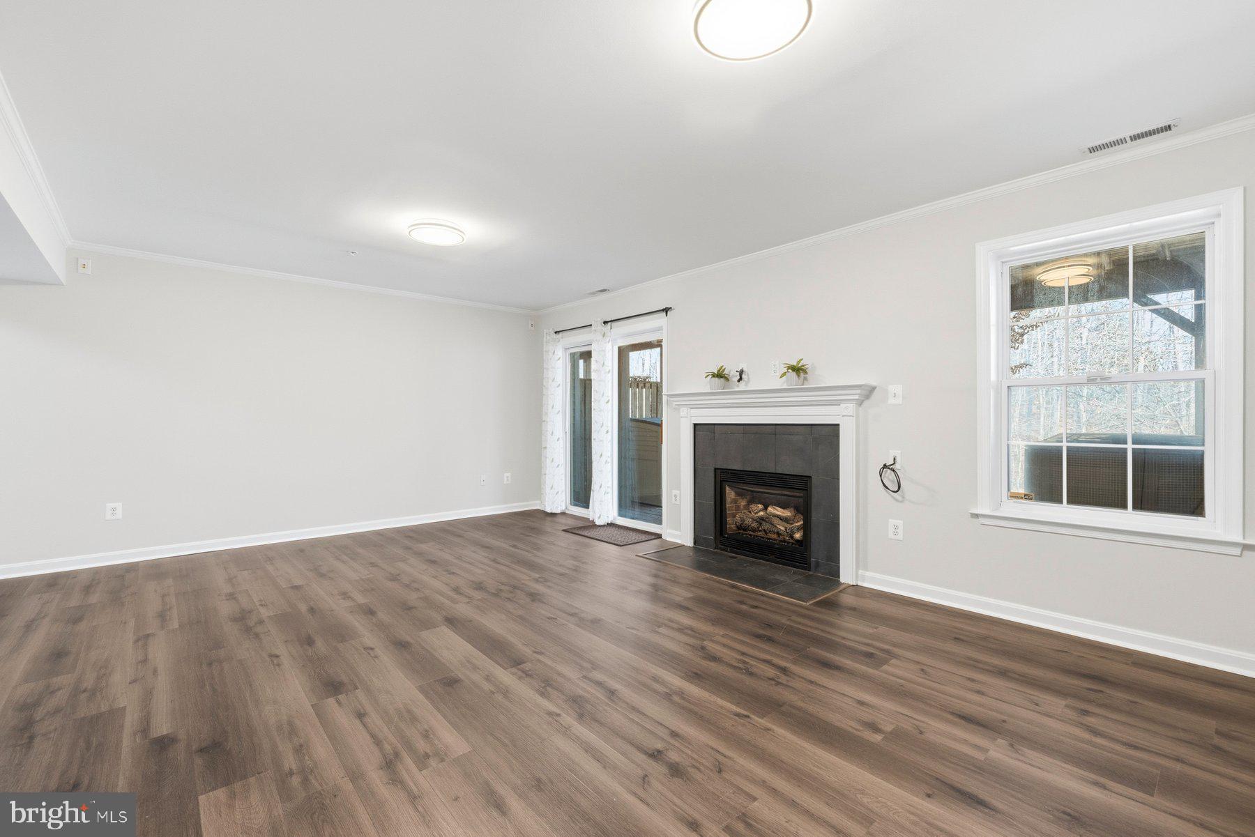 2640 Streamview Drive Odenton, MD 21113 - Photo 35 of 73 a view of an empty room with wooden floor fireplace and a window