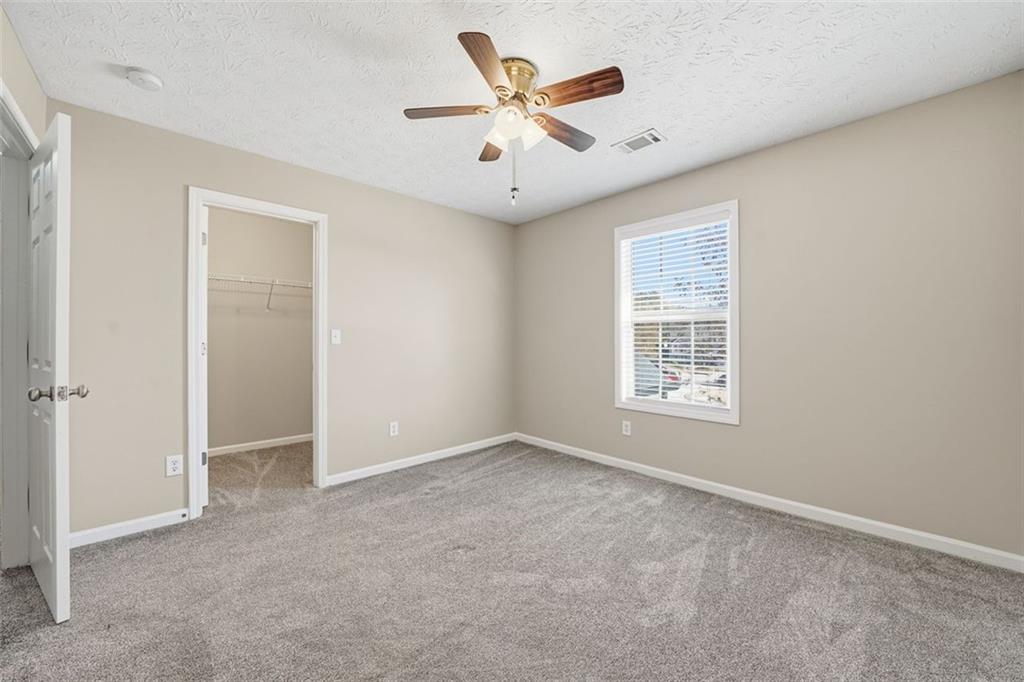 921 Roxeywood Drive Winder, GA 30680 - Photo 40 of 56 an empty room with windows and a ceiling fan