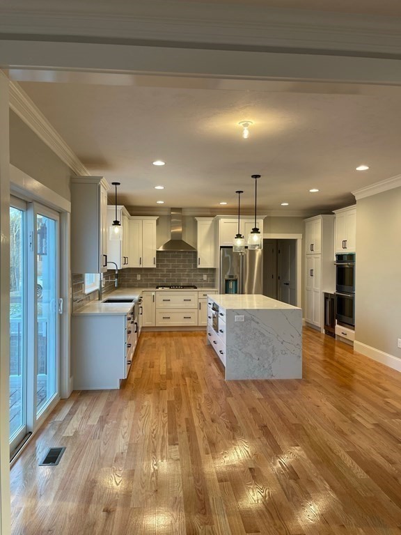 27 Paugus Trail Groton, MA 01450 - Photo 12 of 29 a large kitchen with stainless steel appliances kitchen island a large counter top a stove and a refrigerator