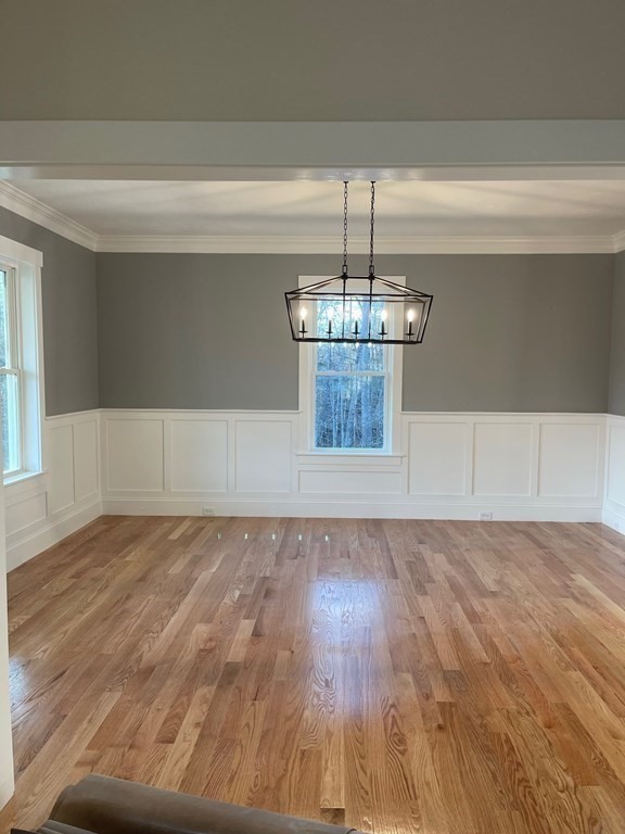 27 Paugus Trail Groton, MA 01450 - Photo 15 of 29 a view of a livingroom with wooden floor and chandelier